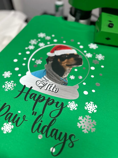 Green t shirt with a dog illustration wearing a Santa hat and text 'Happy Pawlidays' 